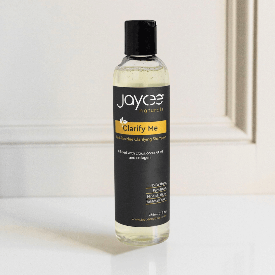 Jaycee Naturals Clarify Me Clarifying Shampoo, infused with citrus and coconut oil and free of parabens, petrolatum, mineral oils, and artificial colors. 236ml bottle standing on a white countertop.