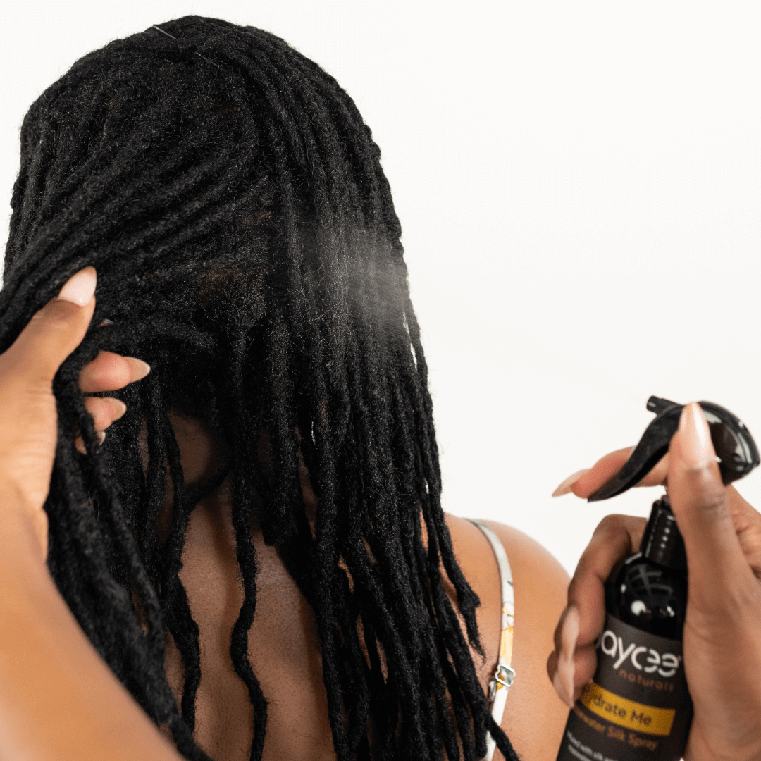 woman with locs getting her hair sprayed with Hydrate Me