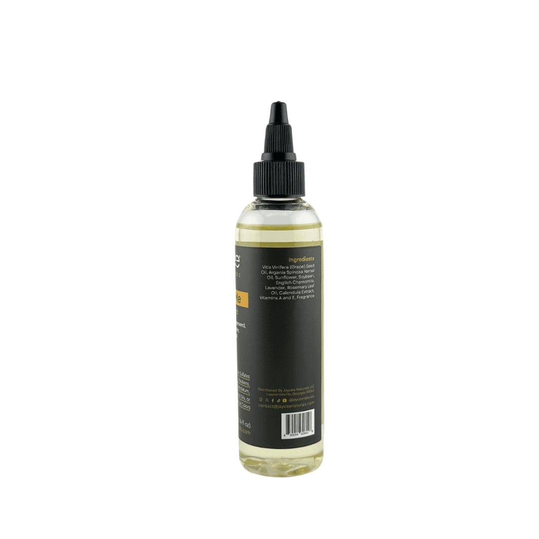 Jaycee Naturals Nourish Me Hair Oil, back view. The label lists ingredients, including grapeseed oil, English chamomile, and rosemary leaf oil.