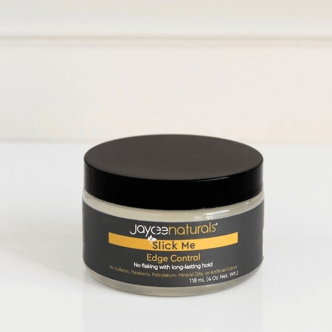 Jaycee Naturals Slick Me Edge Control, free of flaking and with a long-landing hold, and free of sulfates, parabens, petrolatum, mineral oils, and artificial colors. 118ml jar standing on a white countertop.
