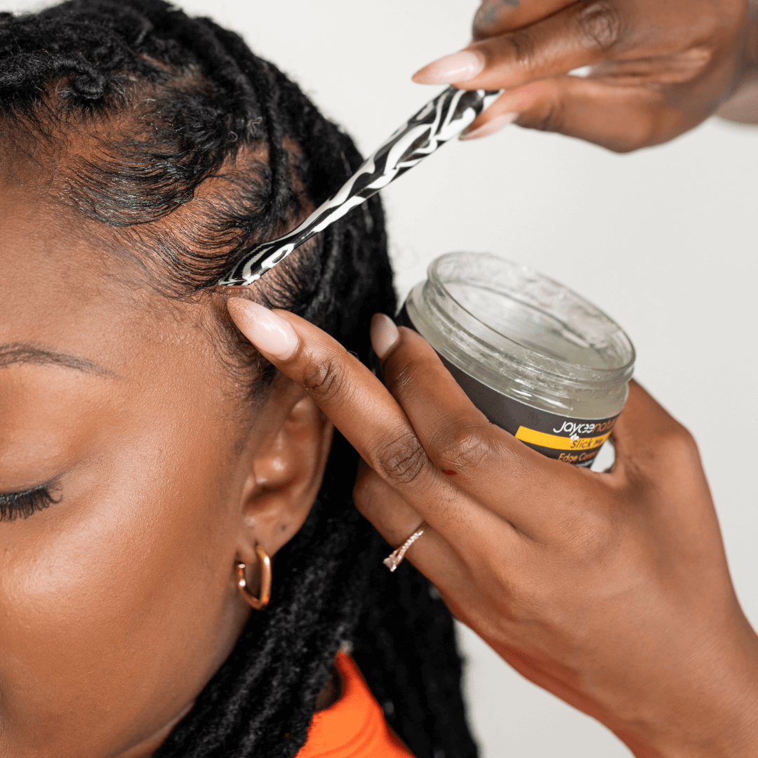Person applying a Slick Me to the edges of a woman's hair.