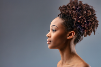 Side profile of woman with 4c hair in a bun