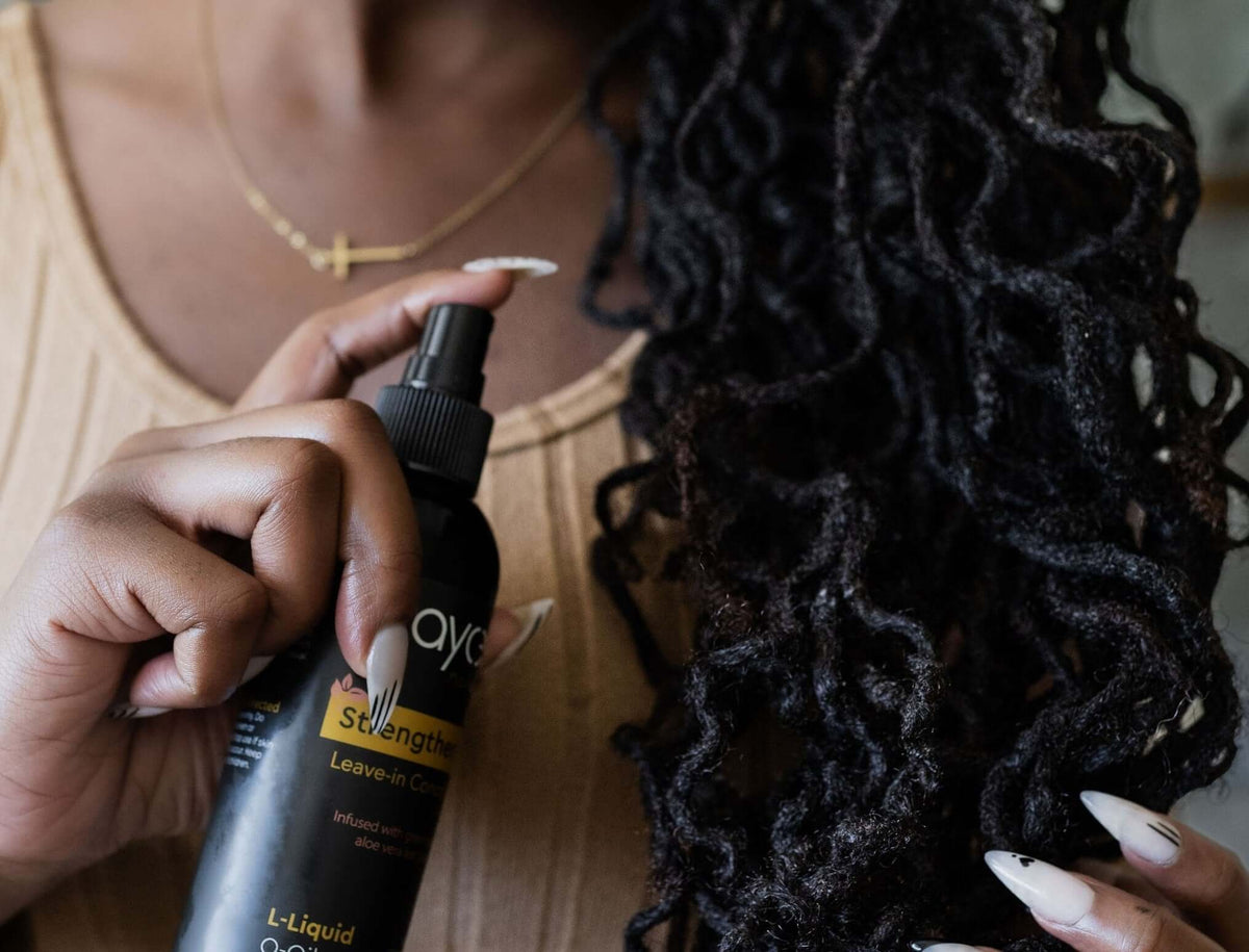 Woman with locs spraying leave-in conditioner
