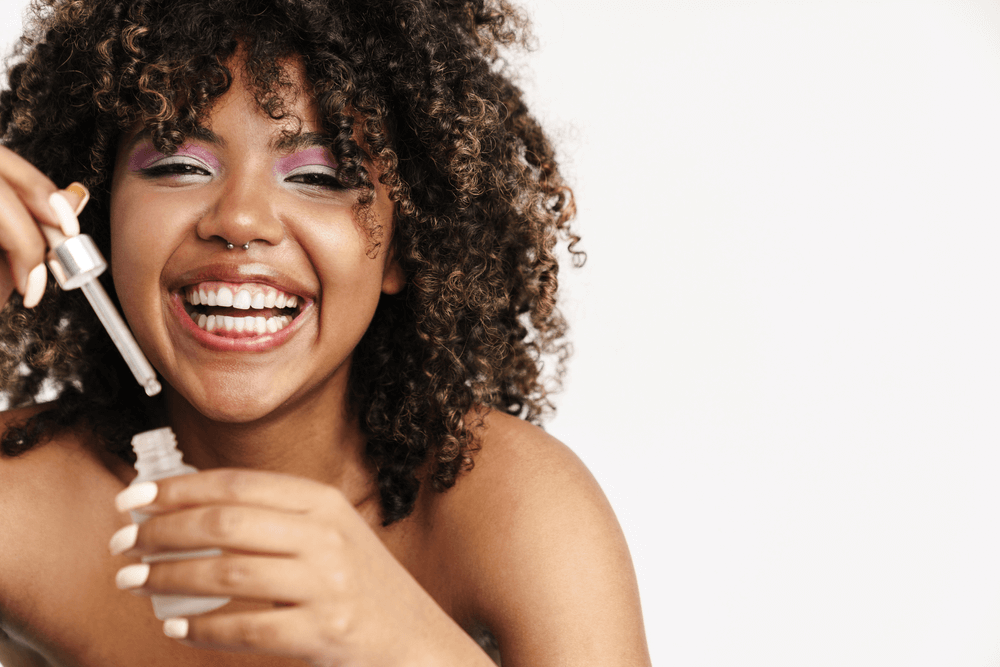 Woman holding a bottle of hair oil