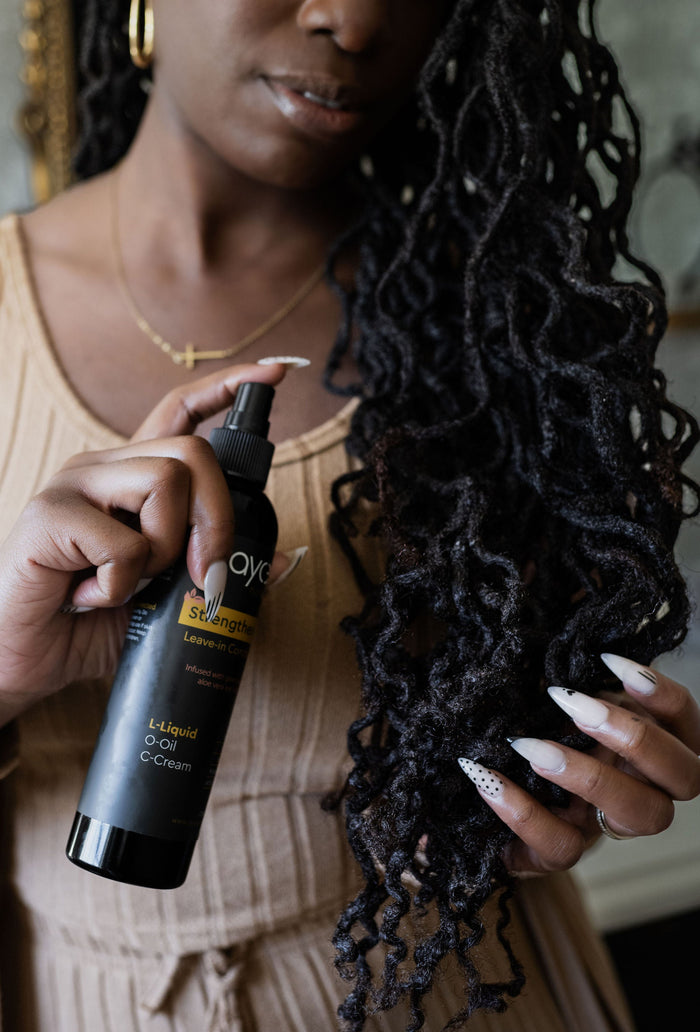 Woman with locs spraying leave-in conditioner