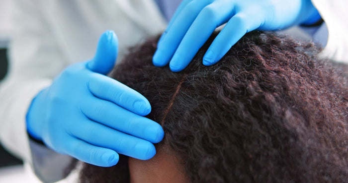 Doctor checking a woman's scalp