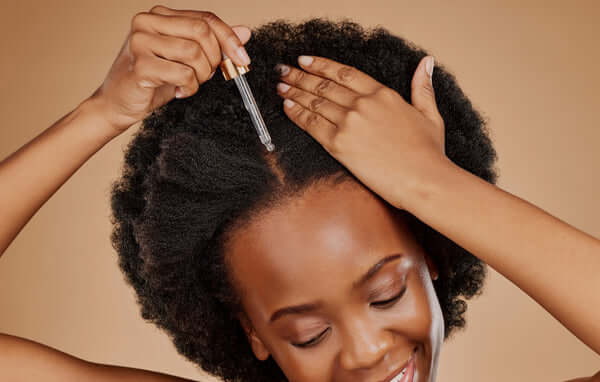 woman applying oil to scalp