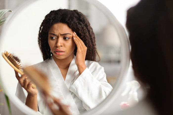 woman looking at hair brush