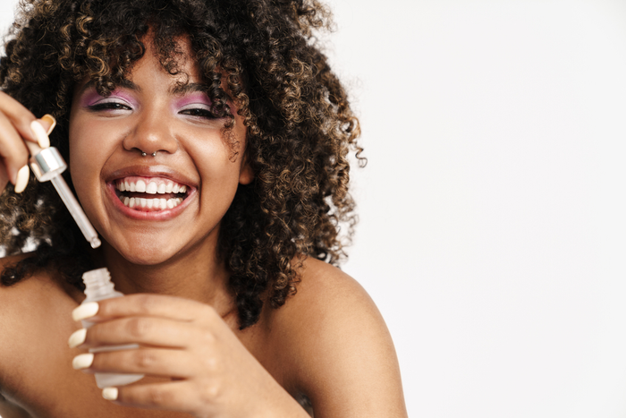 Woman holding a bottle of hair oil