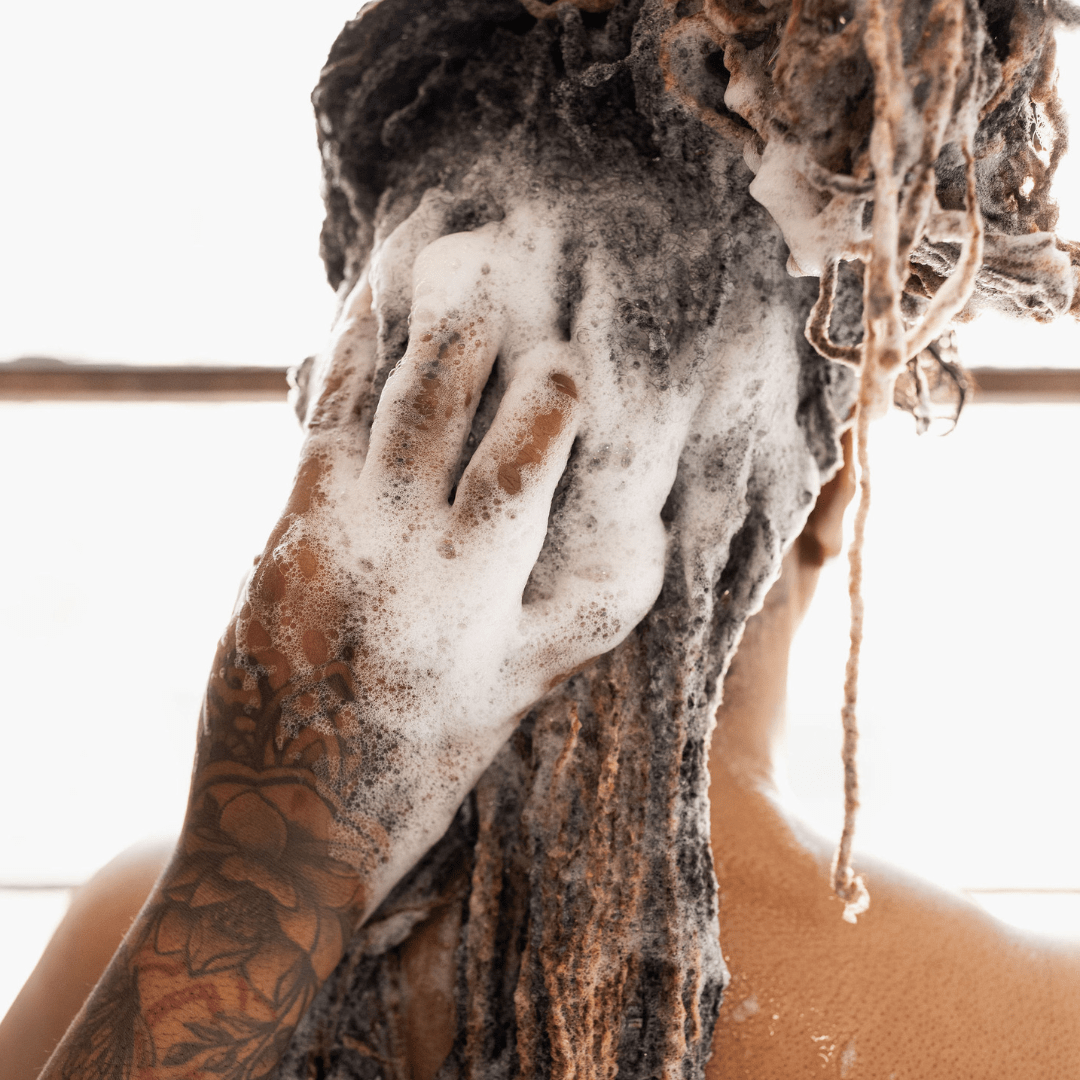 Woman with locs shampooing her hair