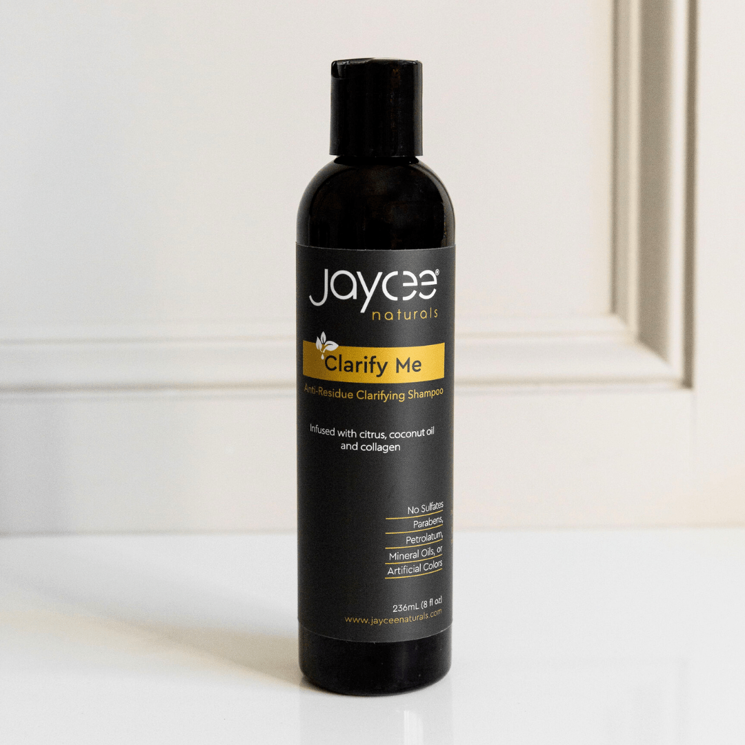 Jaycee Naturals Clarify Me Clarifying Shampoo, infused with citrus and coconut oil and free of sulfates, parabens, petrolatum, mineral oils, and artificial colors. 236ml bottle standing on a white countertop.