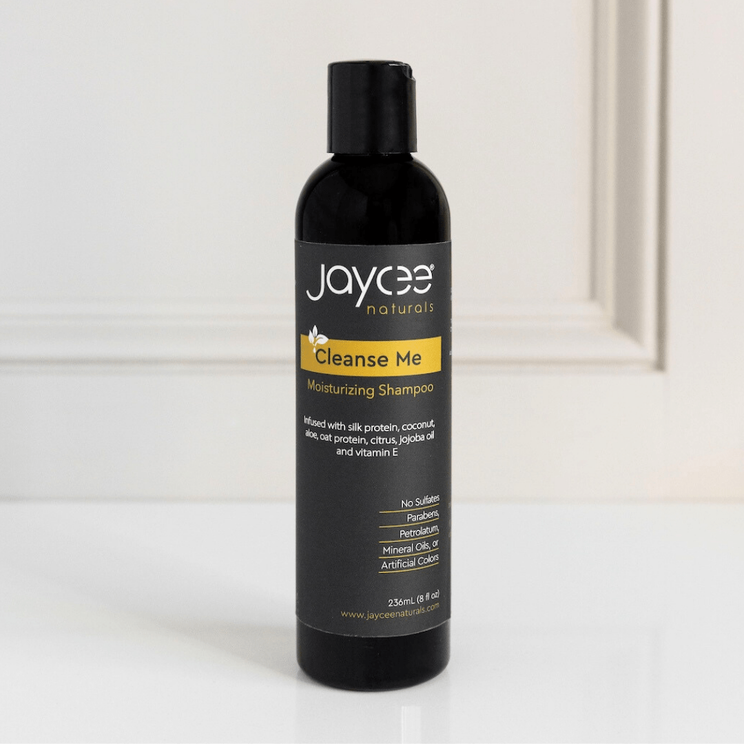 Jaycee Naturals Cleanse Me Moisturizing Shampoo, infused with silk protein and aloe and free of sulfates, parabens, petrolatum, mineral oils, and artificial colors. 236ml bottle standing on a white countertop.