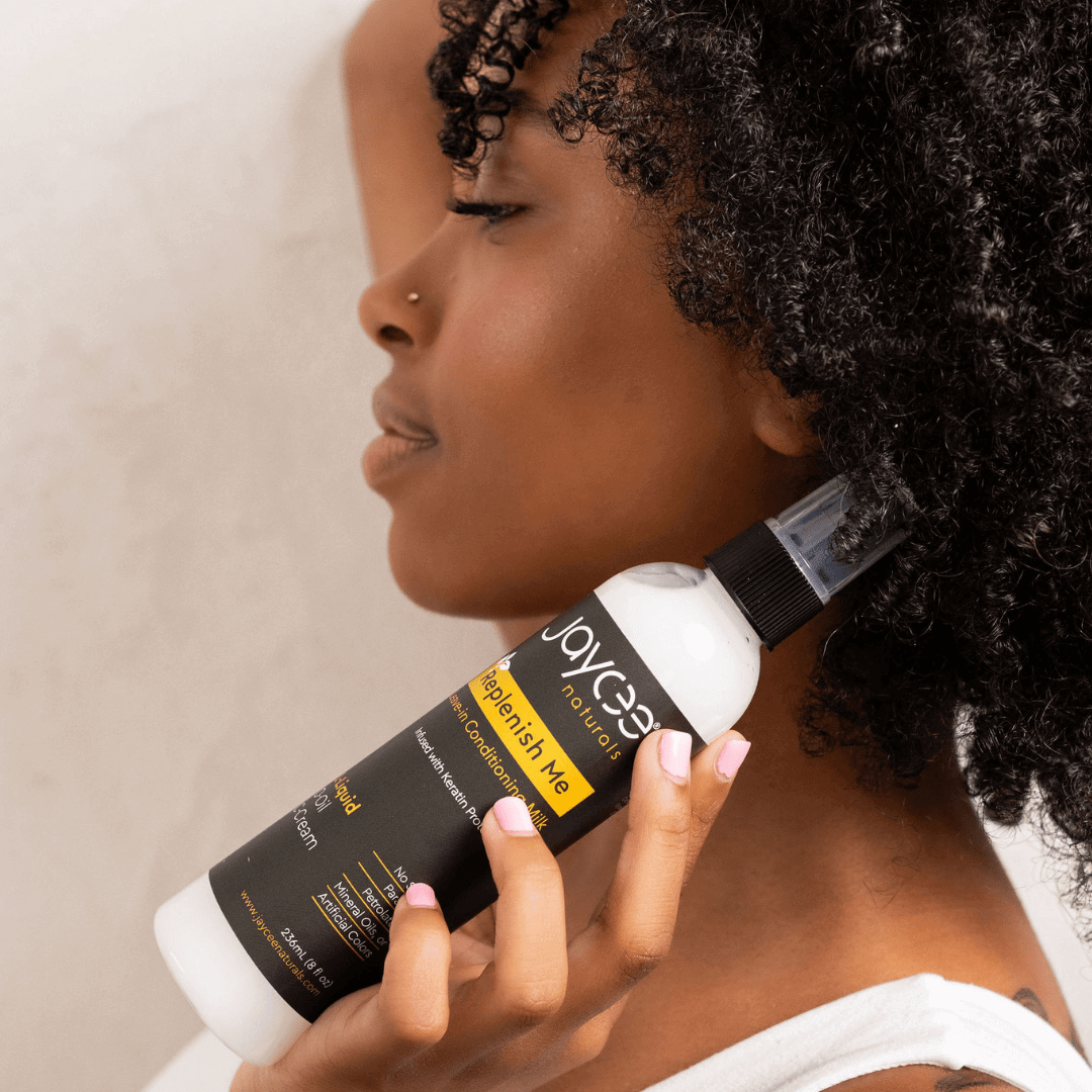 Woman holding a bottle of Replenish Me near her hair