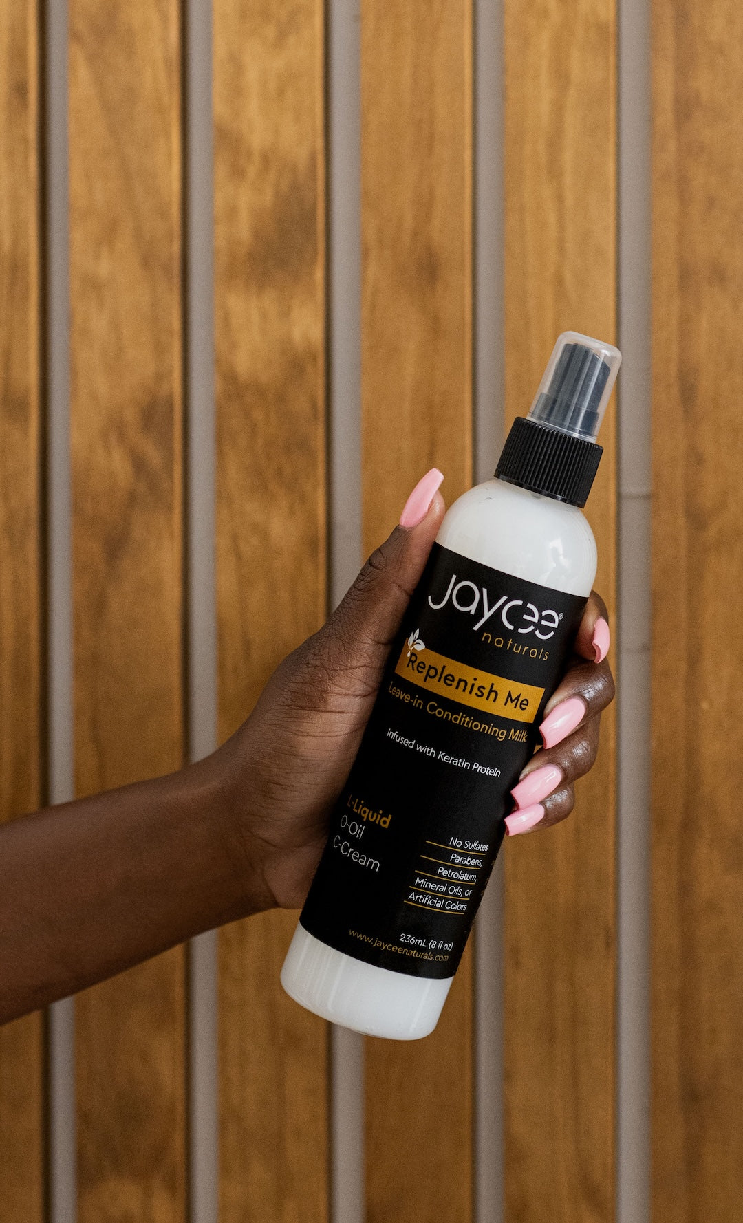 Jaycee Naturals Replenish Me Leave-In Conditioning Milk held in a woman’s hand.