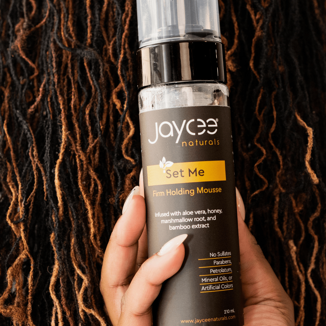 A bottle of Set Me posed in front of locs