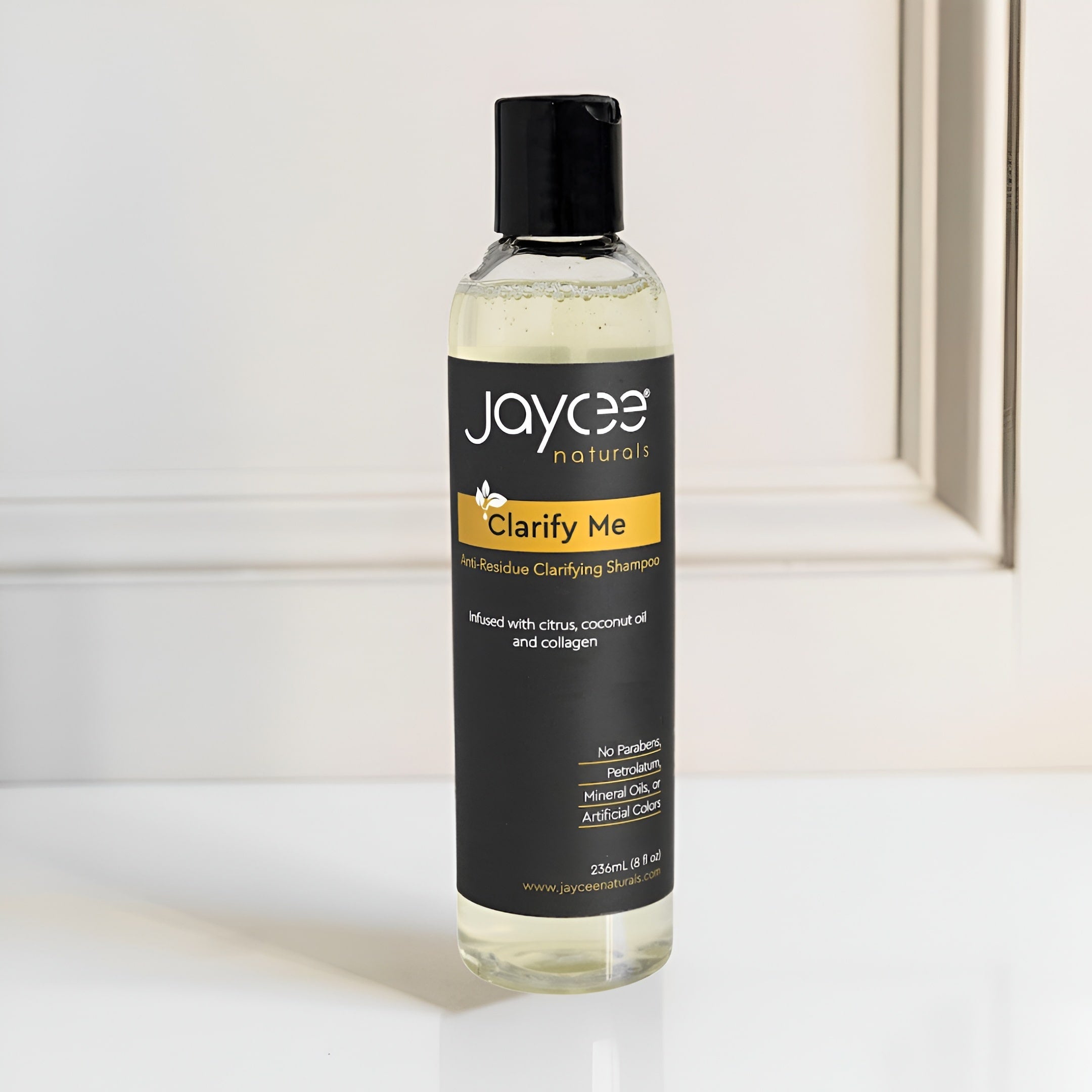 Bottle of Jaycee Naturals Clarify Me shampoo on a light background