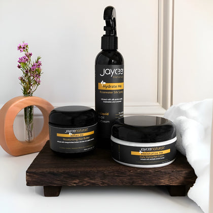 Jayce Naturals hair care products on a wooden tray with a white background