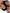 close up face view of two models laying down with one holding a bottle of hair oil between them